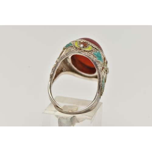 61 - A WHITE METAL CARNELIAN AND ENAMEL DRESS RING, large oval carnelian cabochon, collet set to the fine... 