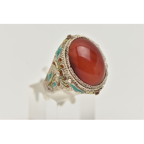 61 - A WHITE METAL CARNELIAN AND ENAMEL DRESS RING, large oval carnelian cabochon, collet set to the fine... 