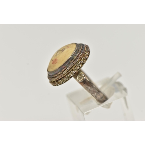 62 - A WHITE METAL RING, of an oval form, set with a cabcohon with bird detail, on a hinged cover, fine r... 