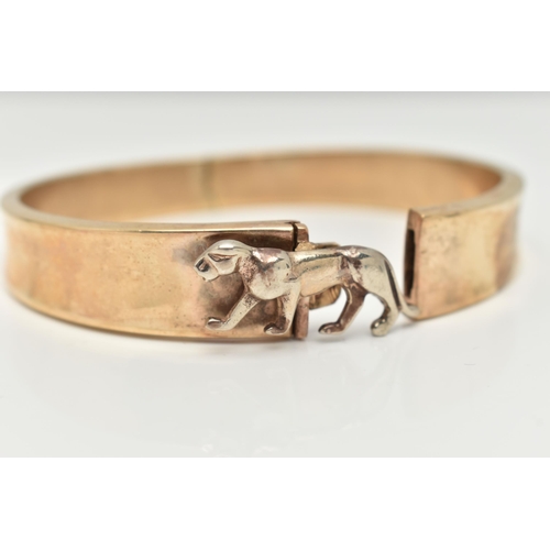 70 - A HINGED BANGLE, the tapered hinged hollow bangle with wild cat push piece clasp, unmarked, approxim... 