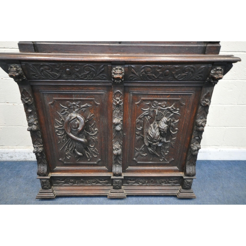 1198 - A LATE 19TH / EARLY 20TH CENTURY CARVED OAK GLAZED BOOKCASE, depicting lions masks and other detail,... 