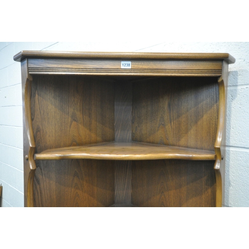 1238 - AN ERCOL ELM OLD COLONIAL CORNER CUPBOARD, with two fixed shelves, above a single cupboard door widt... 