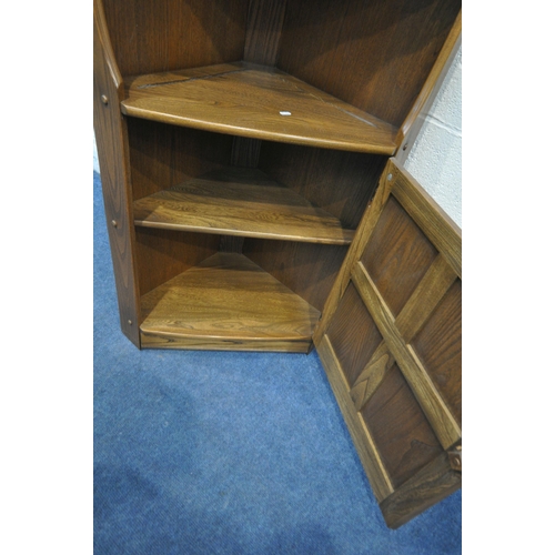 1238 - AN ERCOL ELM OLD COLONIAL CORNER CUPBOARD, with two fixed shelves, above a single cupboard door widt... 