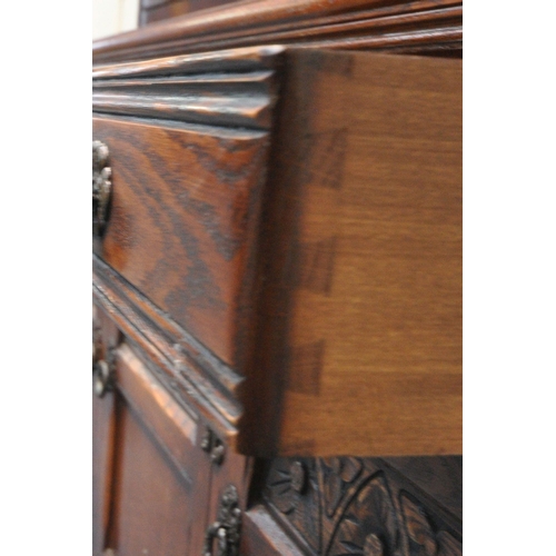 1252 - A 20TH CENTURY OLD CHARM OAK BOOKCASE, the top with double lead glazed doors, enclosing three glass ... 