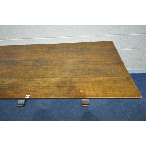 1282 - A 20TH CENTURY OAK REFECTORY TABLE, raised on chamfered block supports, shaped feet, united by a blo... 