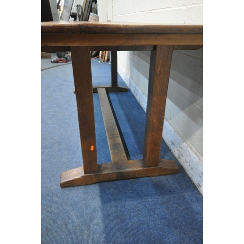 1283 - A 20TH CENTURY OAK REFECTORY TABLE, raised on four block supports, shaped feet, united by a stretche... 