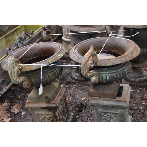 1023 - A PAIR OF EARLY 20th CENTURY CAST IRON URNS ON STANDS with fluted baluster bowl on a square foot and... 