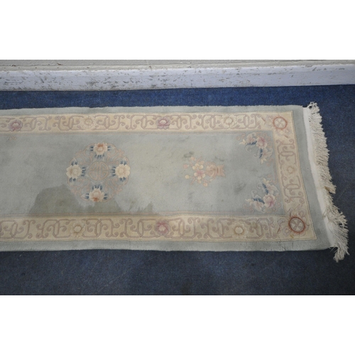 1292 - A CHINESE MINT GREEN GROUND RUNNER, with two medallions, with beige border, 310cm x 76cm (condition ... 