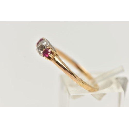 20 - A YELLOW METAL DIAMOND AND RUBY THREE STONE RING, centering on an old cut diamond, estimated diamond... 