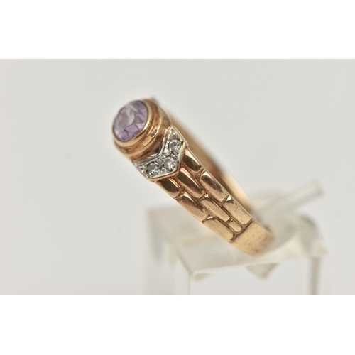 26 - A 9CT GOLD AMETHYST RING, the central oval amethyst in a collet setting, flanked by colourless paste... 