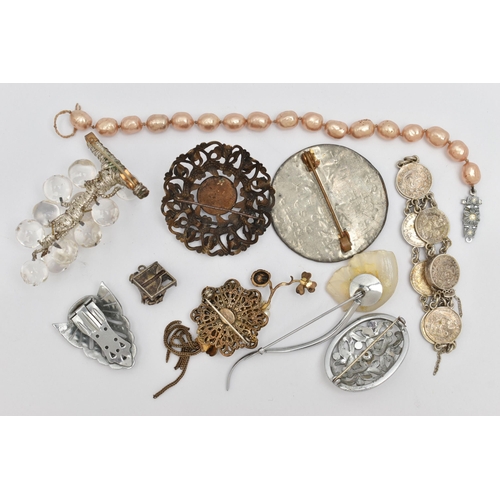 74 - AN ASSORTMENT OF JEWELLERY, to include five brooches, a white metal charm, a clip, a coin bracelet a... 