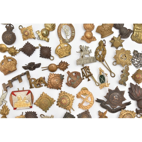 83 - AN ASSORTMENT OF MILITARY CAP BADGES AND PINS, brass badges from assorted British regiments