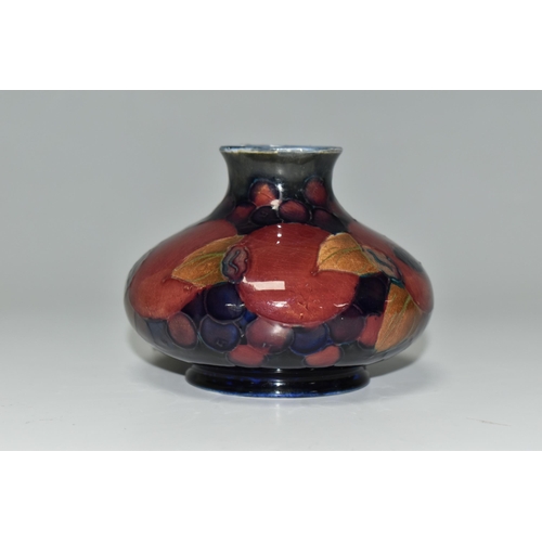 329 - A MOORCROFT 'POMEGRANITE' DESIGN SQUAT VASE,  purple pomegranate on a dark blue ground, height 7cm, ... 