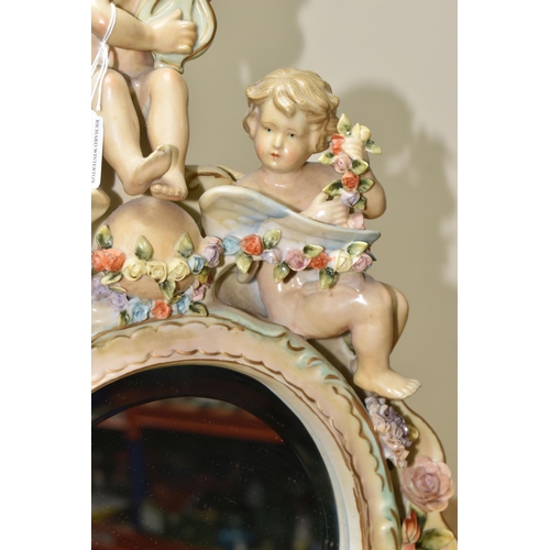 440 - AN EARLY 20TH CENTURY SITZENDORF PORCELAIN FLORAL ENCRUSTED AND FIGURAL MIRROR, modelled with three ... 