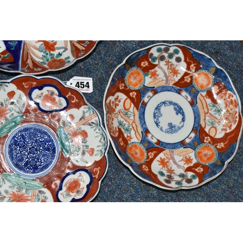 454 - THREE LATE 19TH CENTURY JAPANESE IMARI PLATES, all with wavy rims, varying designs with flora and fi... 