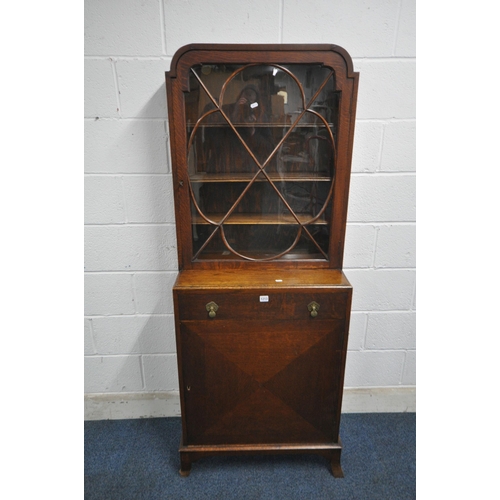 1213 - A 20TH CENTURY OAK CABINET, the single glazed door enclosing three adjustable shelves, above a singl... 