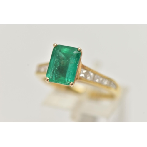 23 - A YELLOW METAL EMERALD AND DIAMOND RING, centering on an emerald cut emerald, measuring approximatel... 