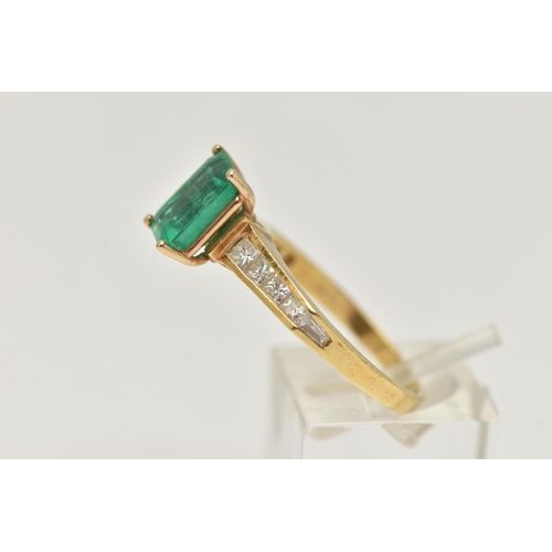 23 - A YELLOW METAL EMERALD AND DIAMOND RING, centering on an emerald cut emerald, measuring approximatel... 