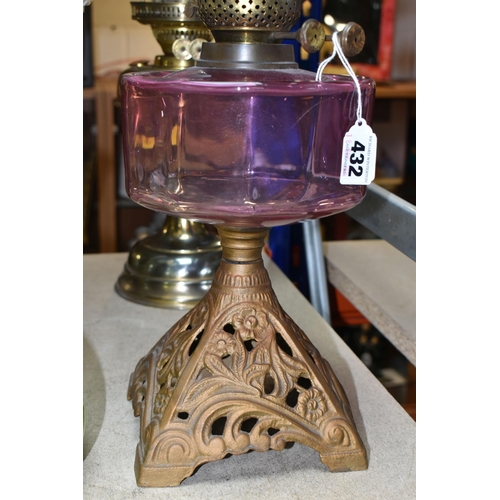 432 - THREE OIL LAMPS AND SHADES, comprising a lamp with a pierced cast iron base and cranberry glass oil ... 