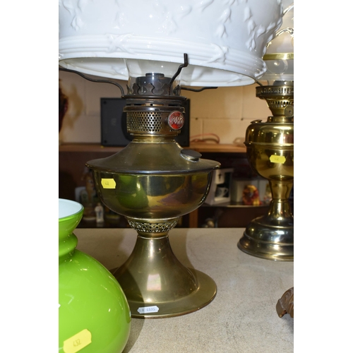 432 - THREE OIL LAMPS AND SHADES, comprising a lamp with a pierced cast iron base and cranberry glass oil ... 