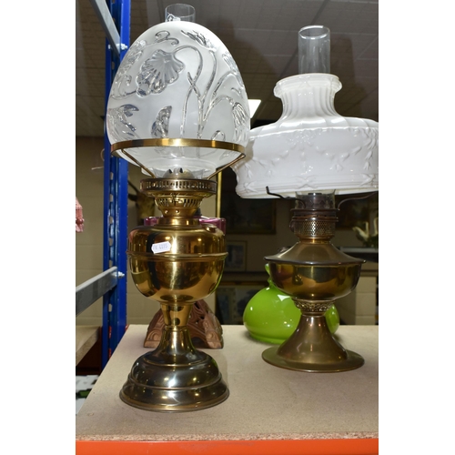 432 - THREE OIL LAMPS AND SHADES, comprising a lamp with a pierced cast iron base and cranberry glass oil ... 