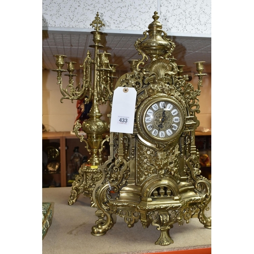 433 - A BRASS FRANZ HERMLE CLOCK GARNITURE, the clock having a chapter ring inset with enamel Roman Numera... 