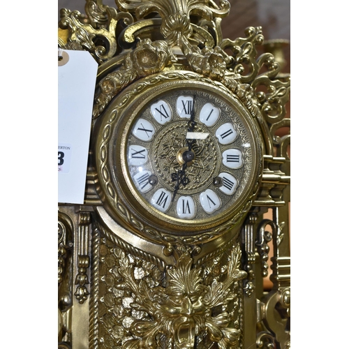 433 - A BRASS FRANZ HERMLE CLOCK GARNITURE, the clock having a chapter ring inset with enamel Roman Numera... 