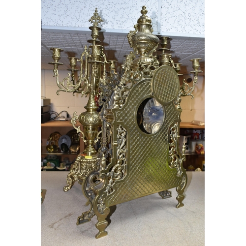 433 - A BRASS FRANZ HERMLE CLOCK GARNITURE, the clock having a chapter ring inset with enamel Roman Numera... 