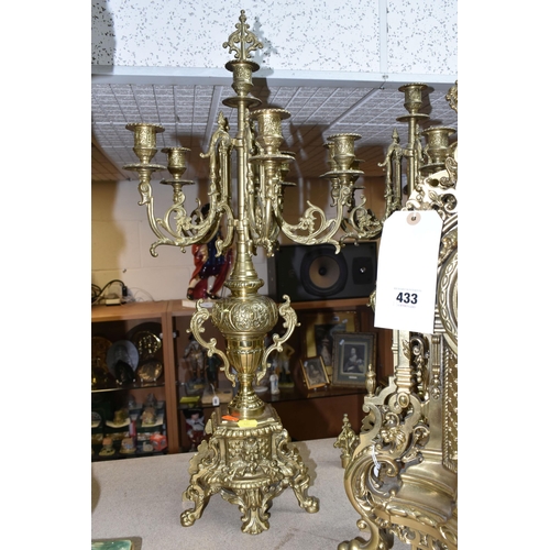 433 - A BRASS FRANZ HERMLE CLOCK GARNITURE, the clock having a chapter ring inset with enamel Roman Numera... 