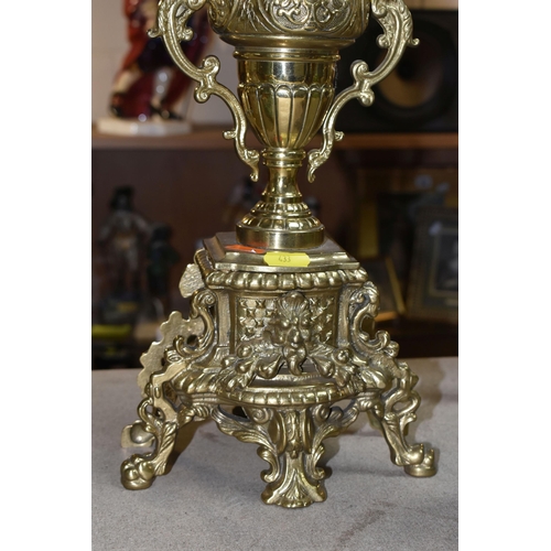 433 - A BRASS FRANZ HERMLE CLOCK GARNITURE, the clock having a chapter ring inset with enamel Roman Numera... 
