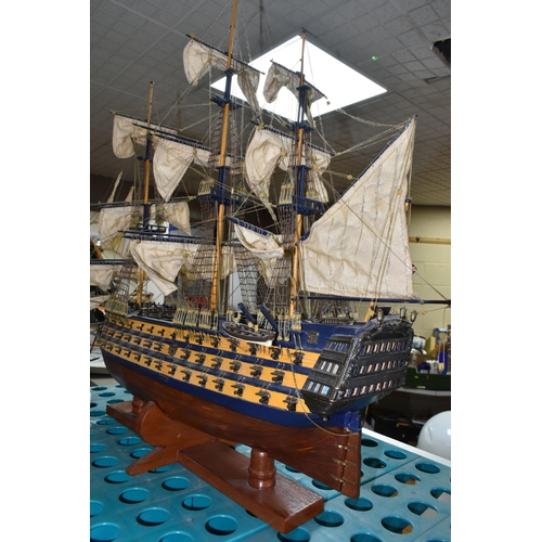 535 - A MODEL OF HMS VICTORY, a wooden ship with cloth sails, supported on a wooden stand with plaque, app... 