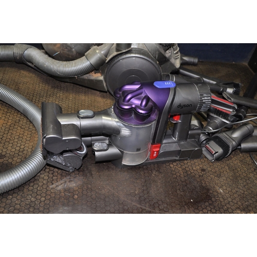 1075 - A DYSON DC31 HANDHELD VACUUM with wall bracket, charger and a quantity of accessories along with a D... 