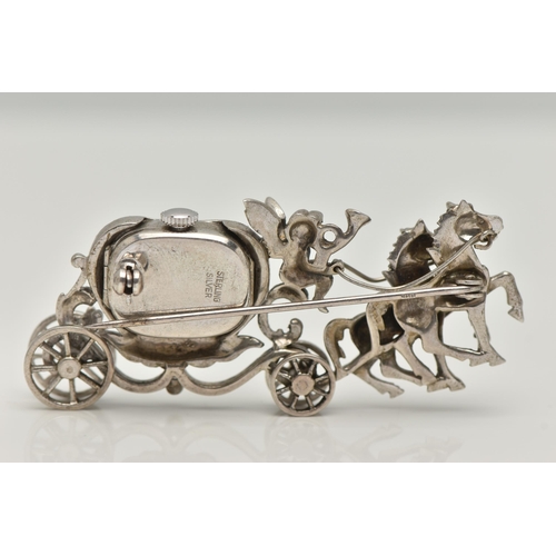 23 - A WHITE METAL WATCH BROOCH, designed as a carriage with a cherub and two horses, set with marcasite,... 