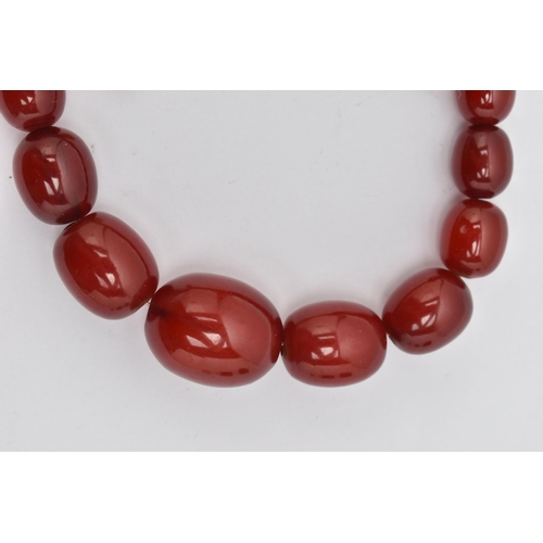 72 - A GRADUATED CHERRY AMBER, BAKELITE BEAD NECKLACE, graduated oval beads, smallest measuring approxima... 