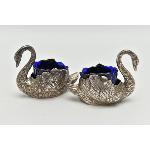 100 - A PAIR OF GEORGE V SILVER NOVELTY SALTS, matching swans with feather detail, with blue glass inserts... 