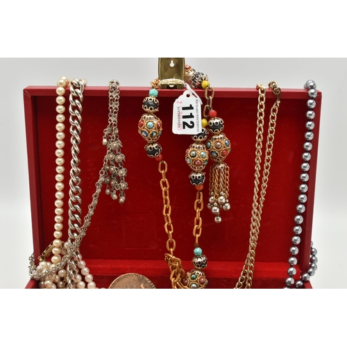 112 - A RED JEWELLERY BOX WITH CONTENTS, to include imitation pearl necklaces, costume chains, novelty Mon... 