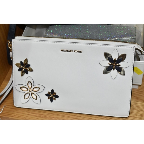 460 - THREE HANDBAGS, comprising a white Michael Kors clutch bag, with three dimensional flower details, a... 