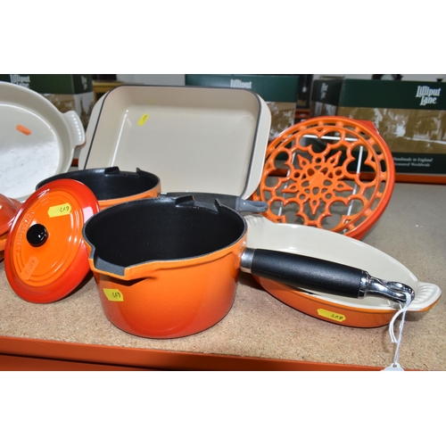 469 - A GROUP OF LE CREUSET VOLCANIC ORANGE PANS AND OVENWARE, comprising two saucepans  size 16, a covere... 