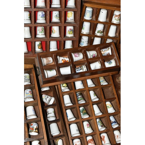 548 - A CERAMIC THIMBLE COLLECTION, to include over one hundred and fifty thimbles in wooden wall hanging ... 