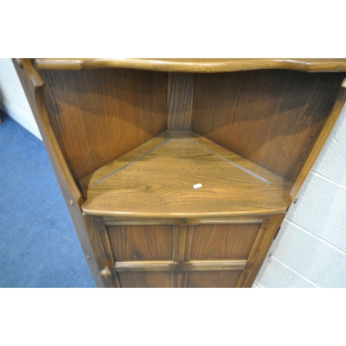 1191 - AN ERCOL ELM OLD COLONIAL CORNER CUPBOARD, with two fixed shelves, above a single cupboard door widt... 