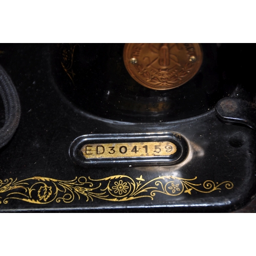 1102 - A CASED SINGER ELECTRIC SEWING MACHINE with green alligator skin effect covering to case (UNTESTED)