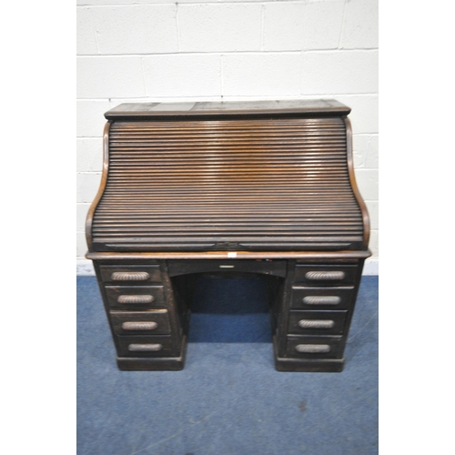 1329 - AN EARLY 20TH CENTURY OAK ROLL TOP DESK, enclosing a fitted interior, on two pedestals, each with fo... 