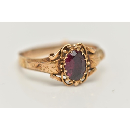 69 - A VICTORIAN YELLOW METAL GARNET RING, centering on an oval cut garnet, claw set, the reverse of the ... 