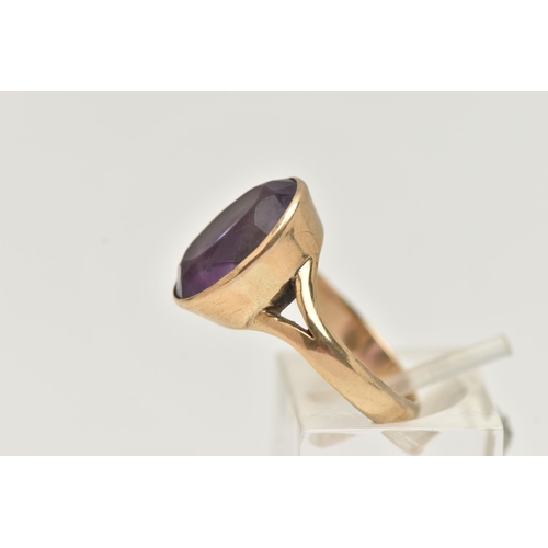 74 - A YELLOW METAL AMETHYST RING, large oval cut amethyst, measuring approximately length 15.2mm x width... 