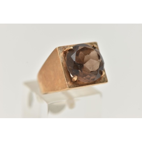 107 - A 9CT GOLD DRESS RING, a circular cut smoky quartz, four prong set in yellow gold, set in a square m... 