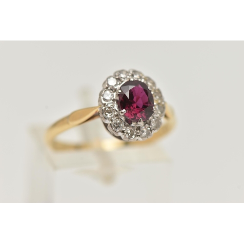 111 - A RUBY AND DIAMOND CLUSTER RING, a principally set oval cut ruby, prong set in white metal, with a s... 