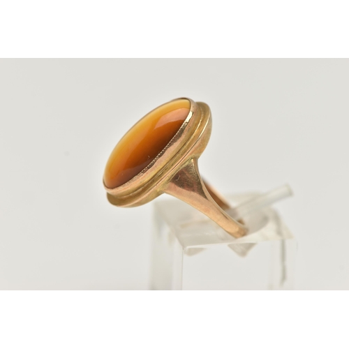 134 - A 9CT GOLD DRESS RING, an elongated oval cabochon tigers eye, collet set in yellow gold, leading on ... 