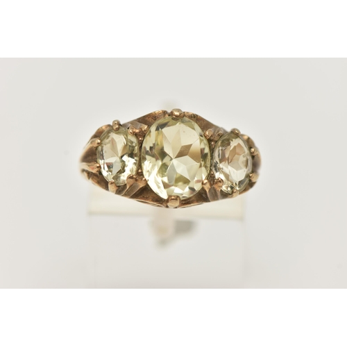 135 - A 9CT GOLD GEM SET RING, three light yellow oval cut quartz stones, prong set in yellow gold, scroll... 