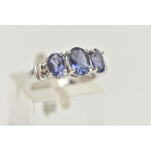 76 - A 9CT WHITE GOLD TANZANITE RING, set with three oval cut tanzanite, each in a four claw setting, wit... 