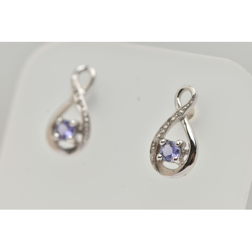 77 - A BOXED PAIR OF 9CT WHITE GOLD TANZANITE AND DIAMOND SET EARRINGS, each earring set with a small cir... 